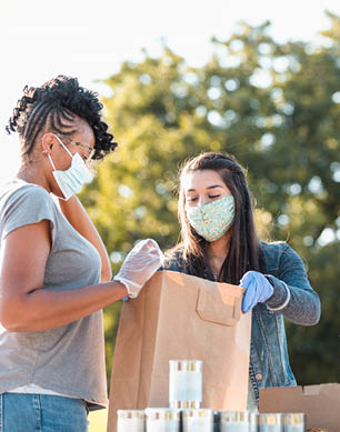 The young women discuss what other food to put into the paper bag at the food drive 