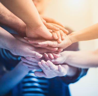 Stack of people's hands one over the other, displaying teamwork